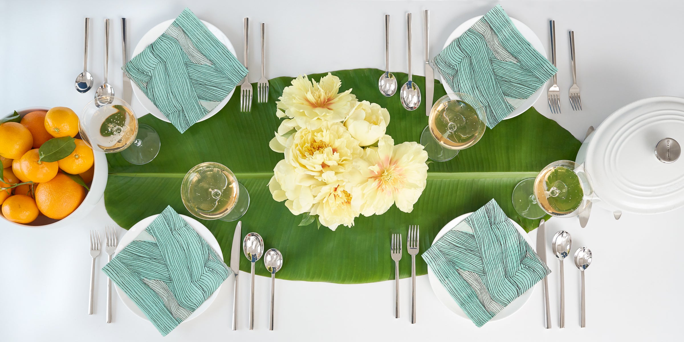 Green, black and off-white dinner napkin with modern abstract pattern in table setting