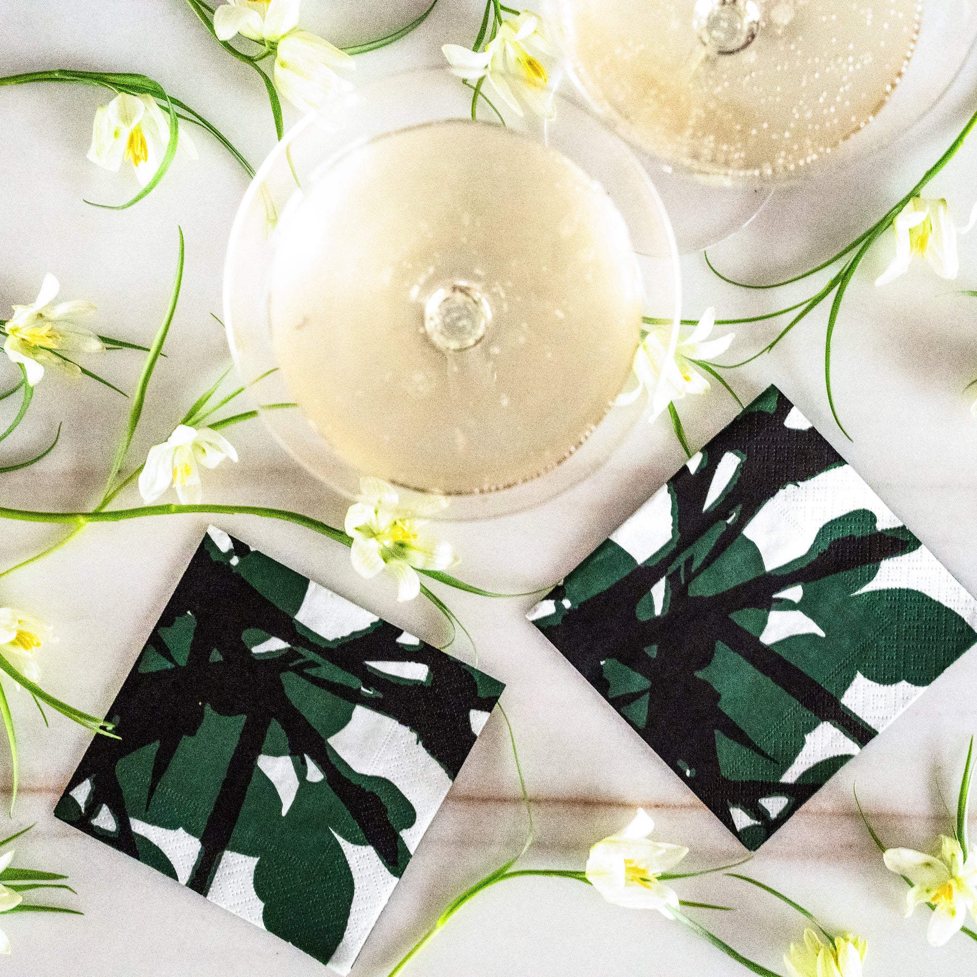 White cocktail napkin with green and black design
