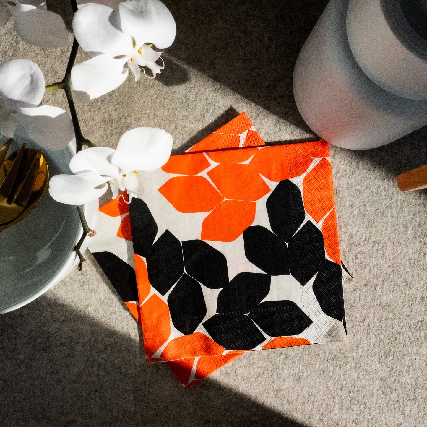 Beige dinner napkin with orange and black design