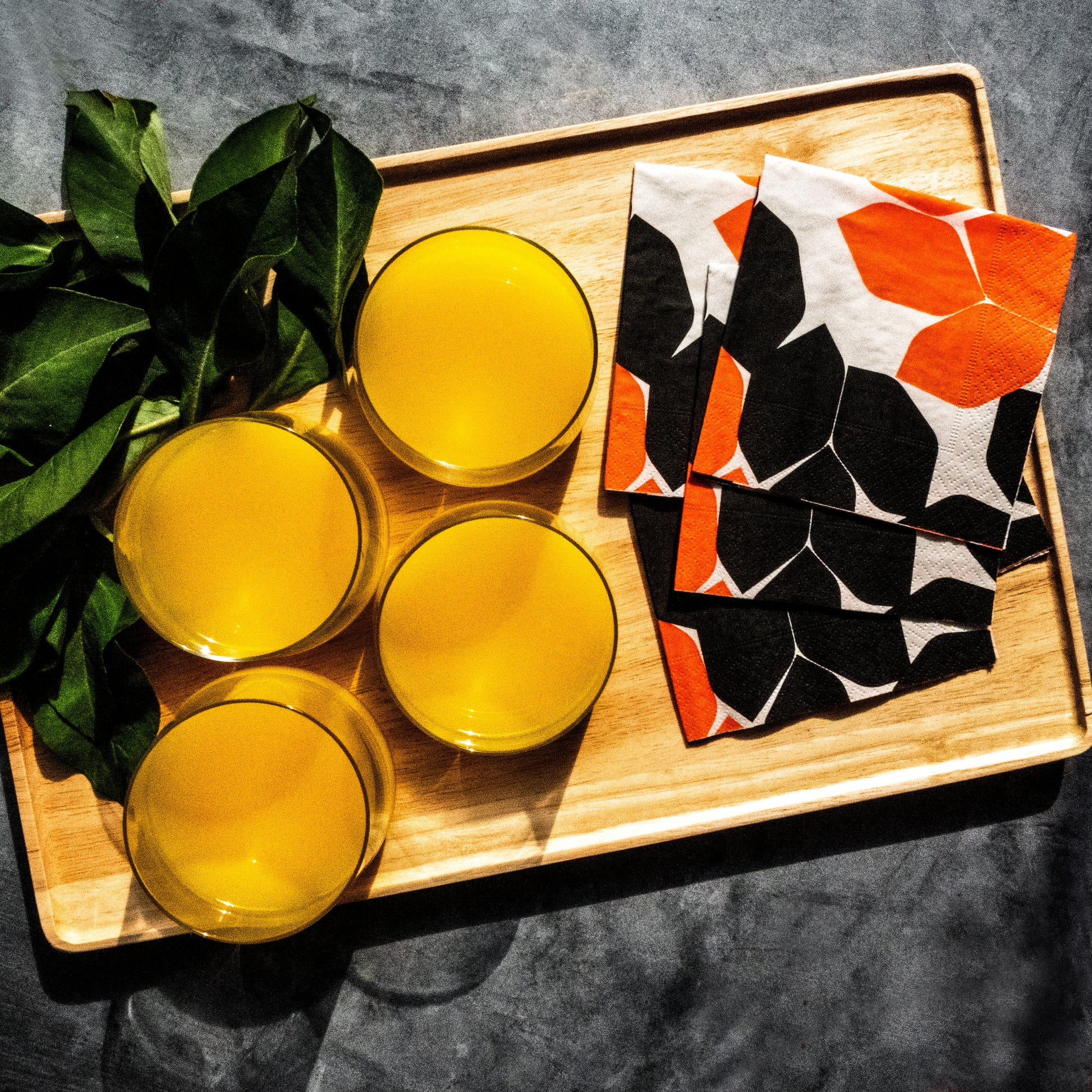 Beige cocktail napkin with orange and black design