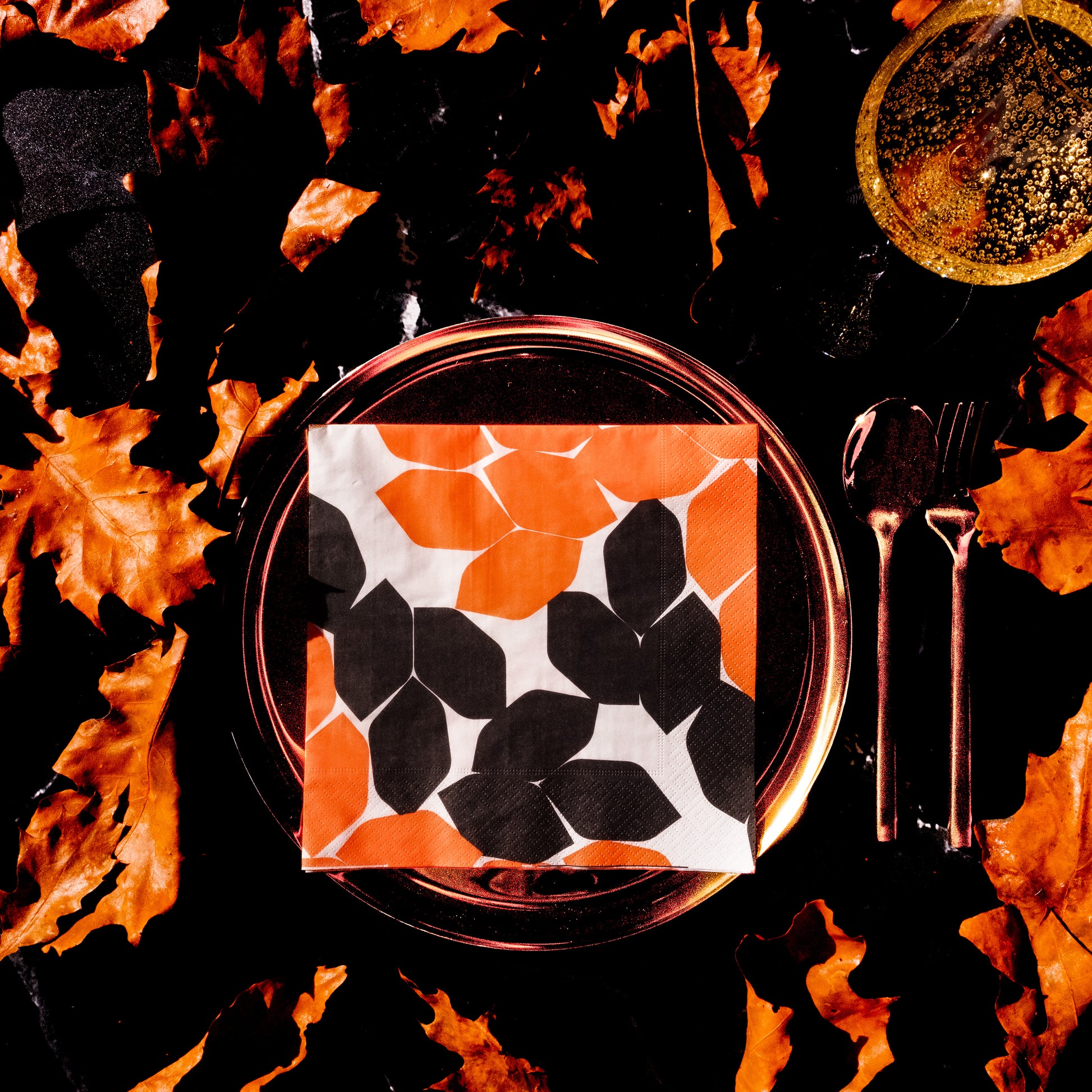 Beige dinner napkin with orange and black design