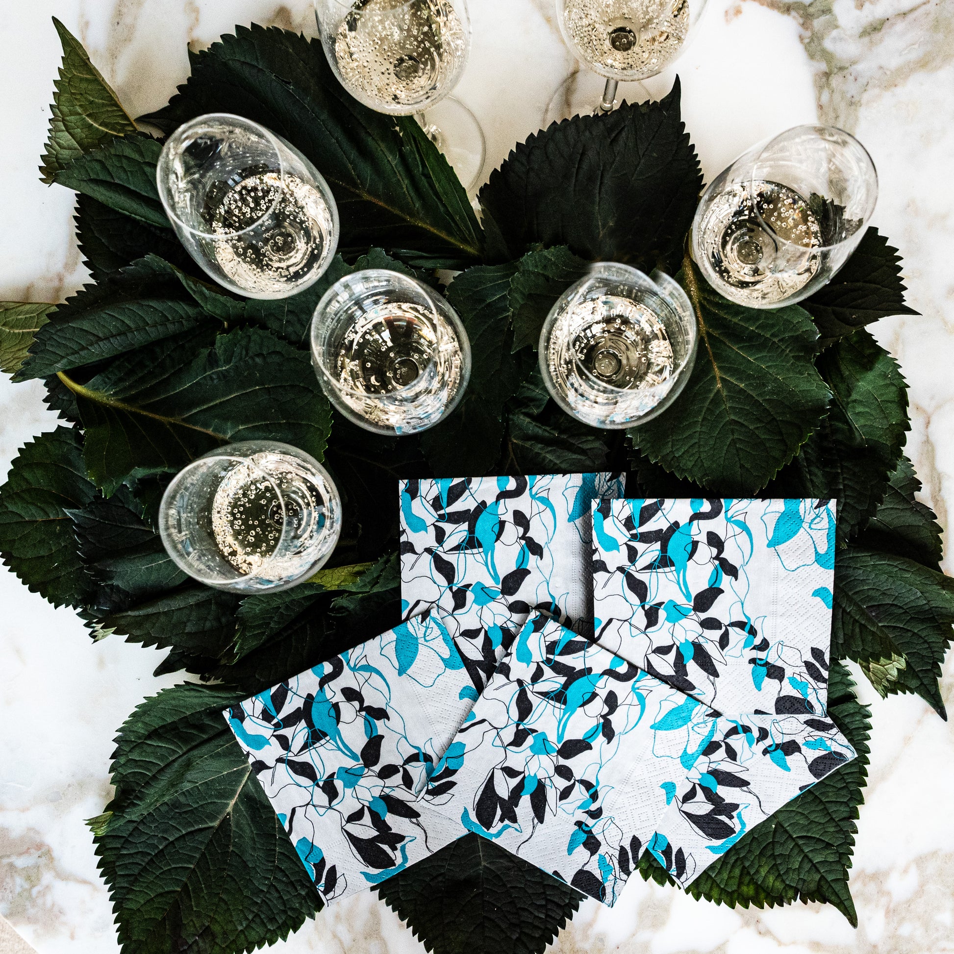 Teal, black and gray cocktail napkin with floral/leaf pattern