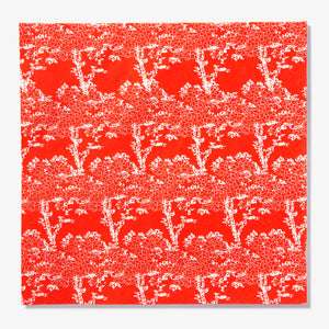 Orange/red dinner napkin with white cherry tree pattern