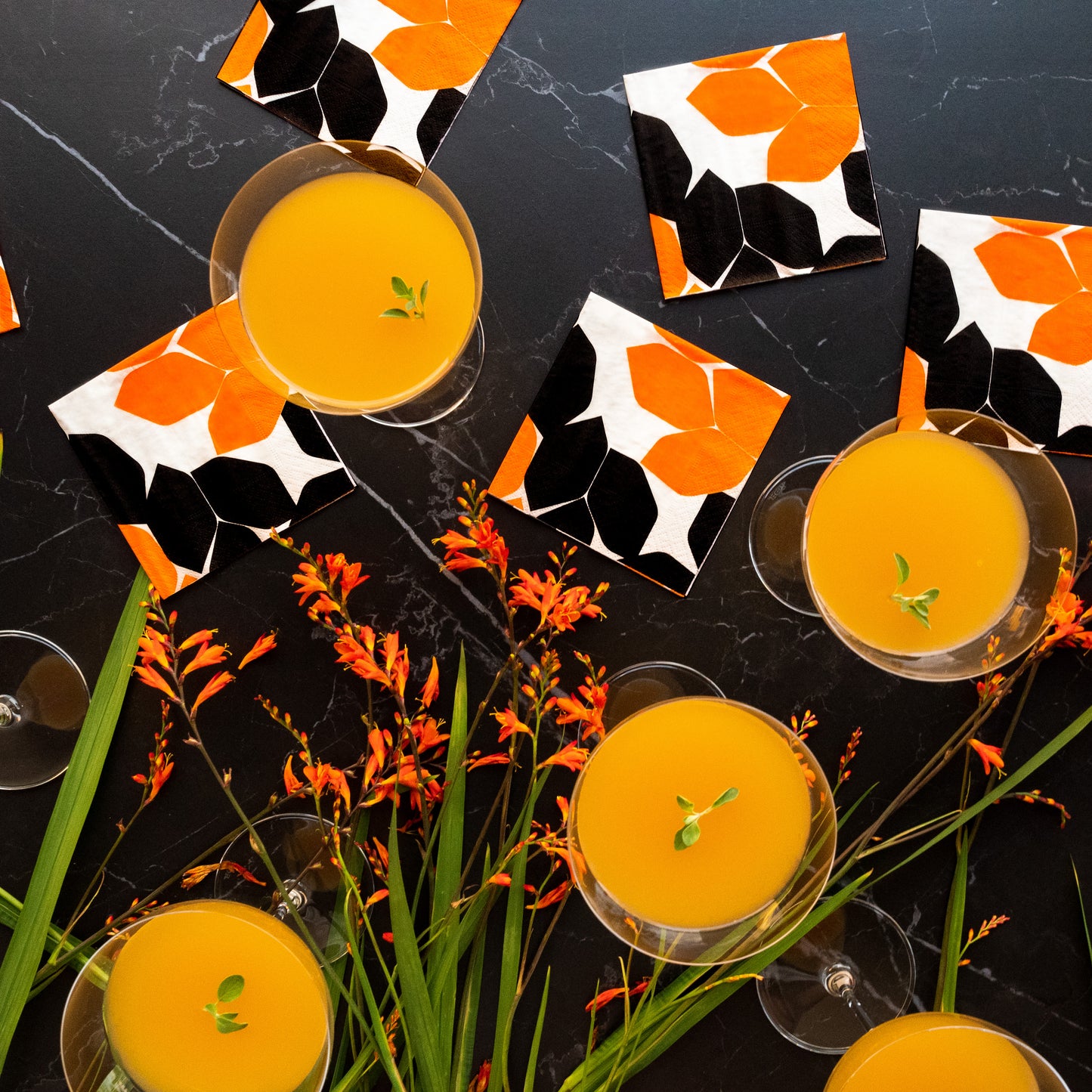 Beige cocktail napkin with orange and black design