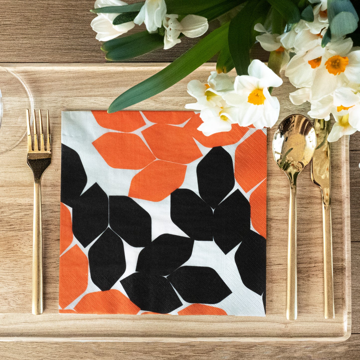 Beige dinner napkin with orange and black design