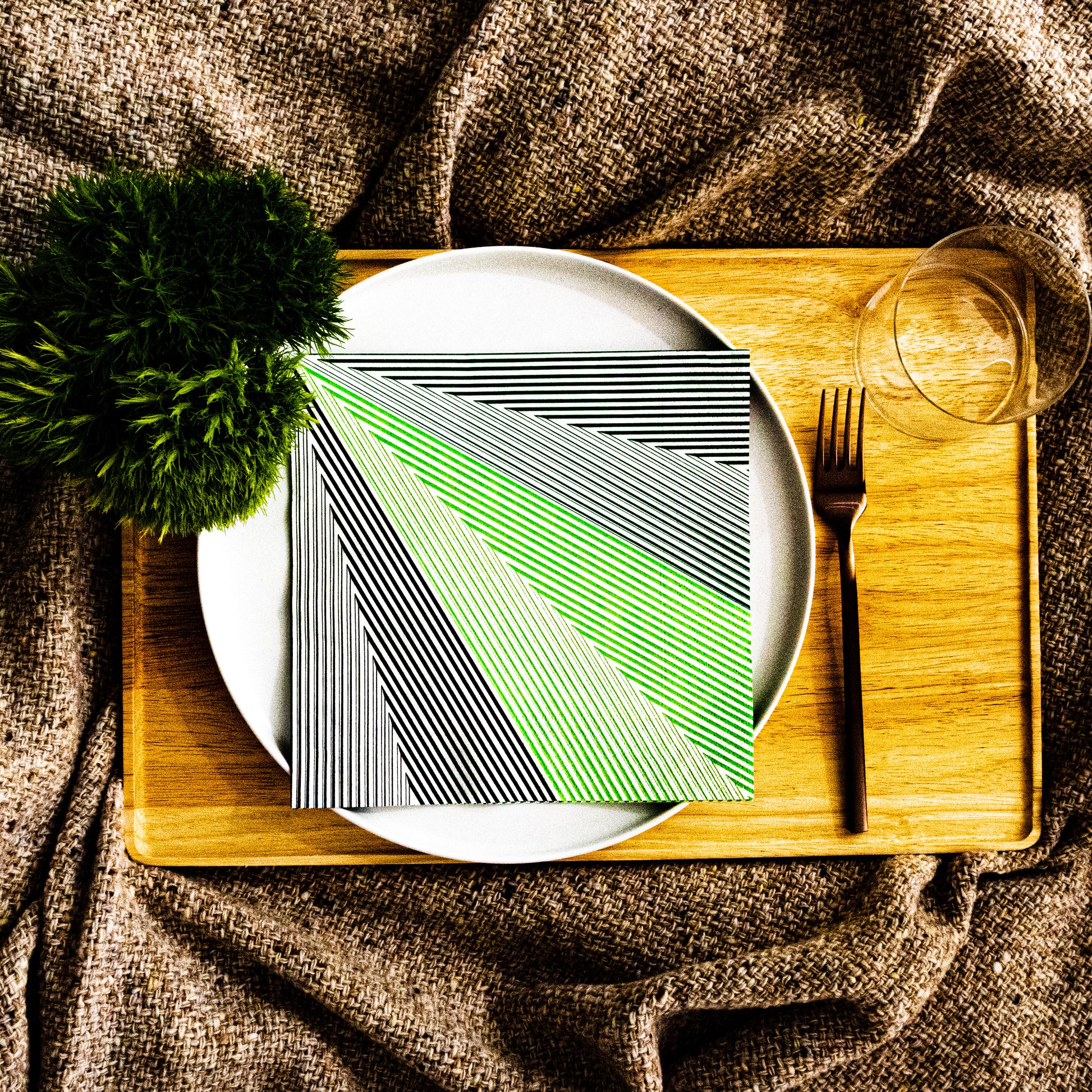 Green, black and white dinner napkin with striped pattern