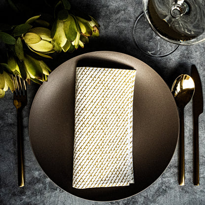 White dinner napkin with gold abstract pattern