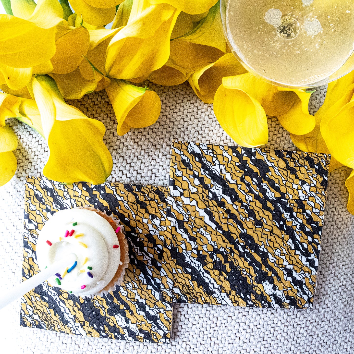 Gold, black and white cocktail napkin with abstract pattern